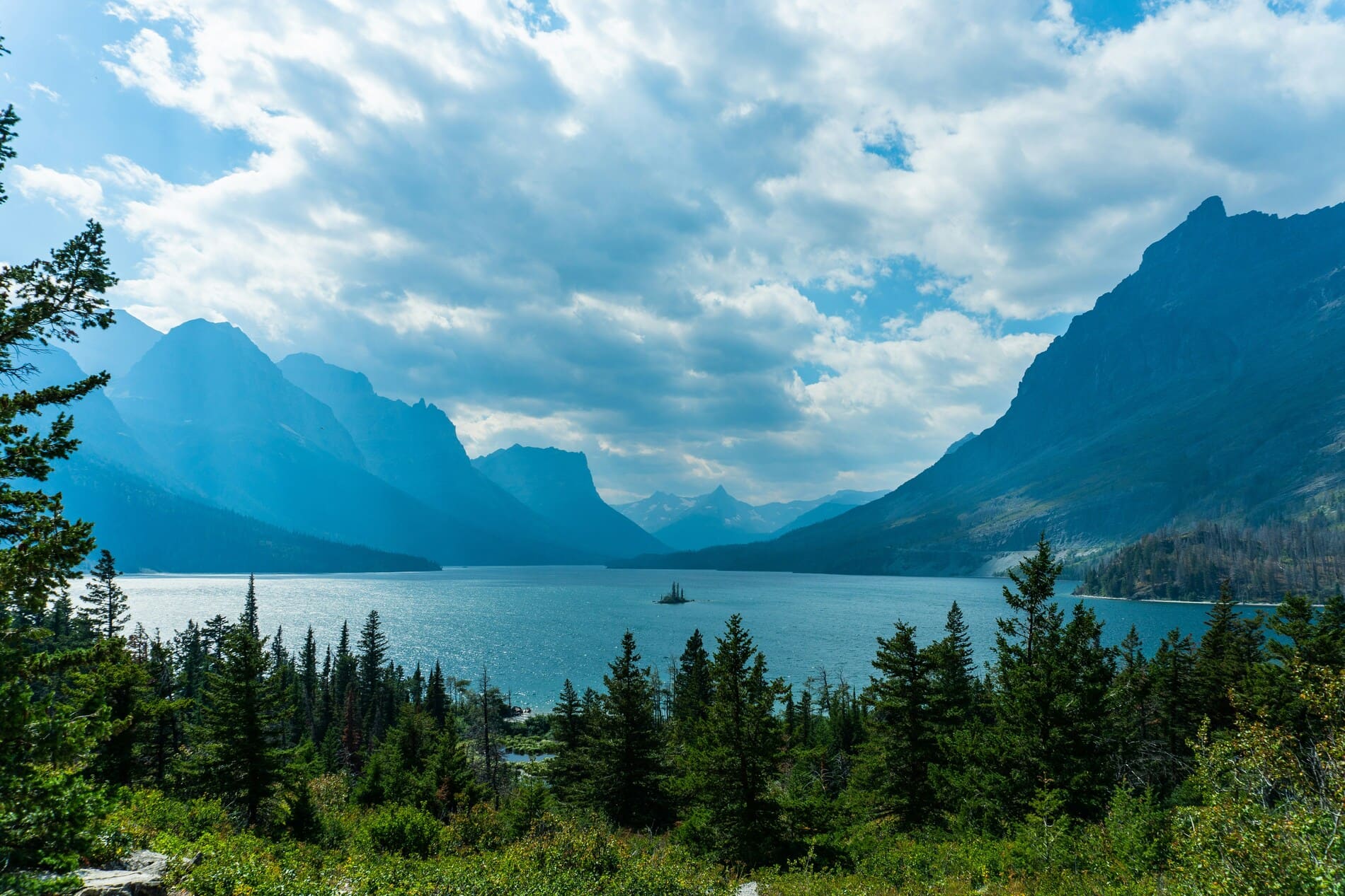 A wide open valley, lake, and mountains during the day in Montana.